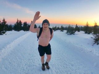 man in sneeuw met hand omhoog