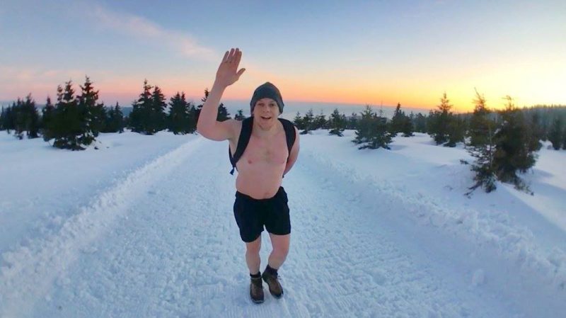 man in sneeuw met hand omhoog